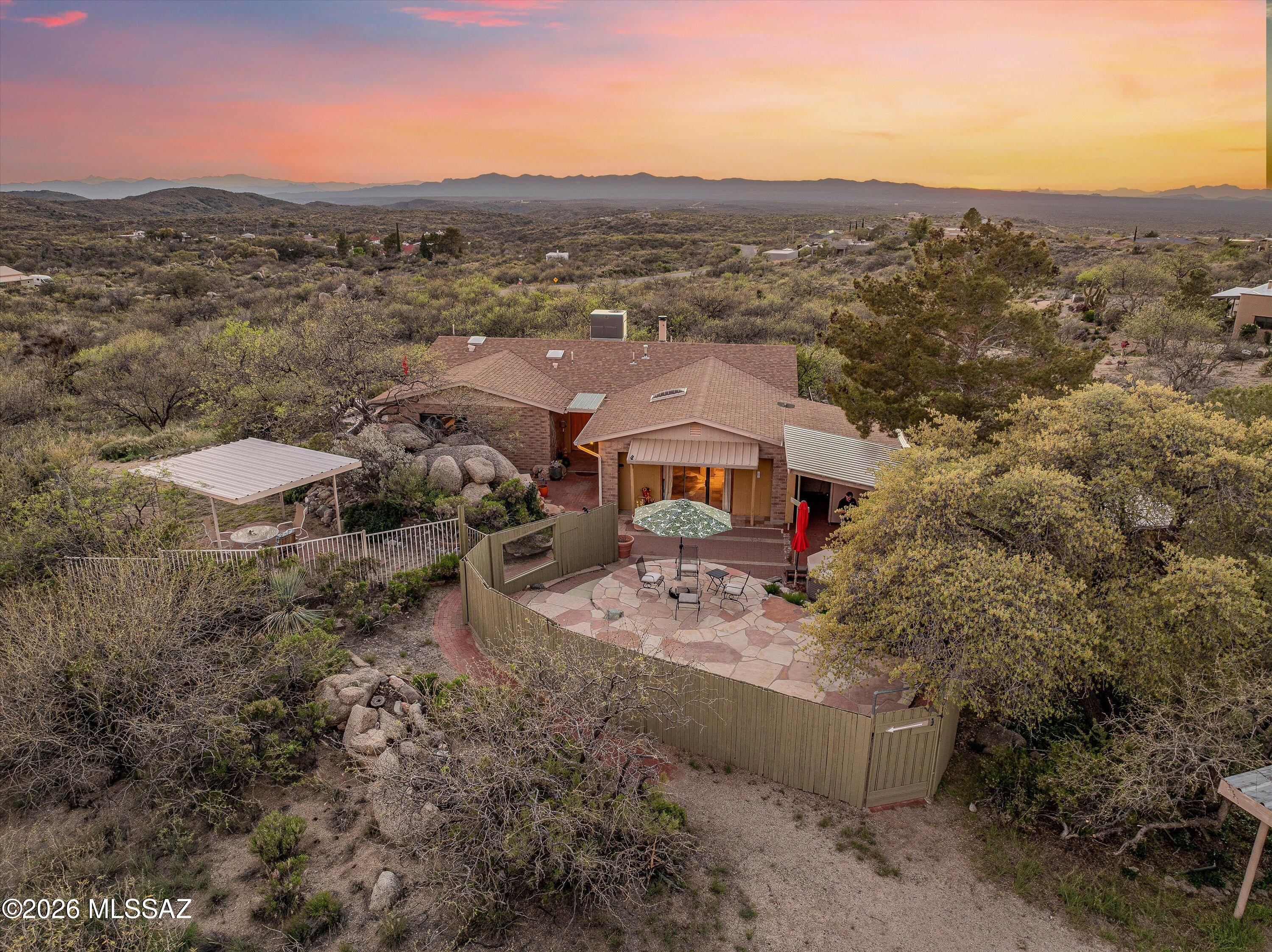 Discover this charming single-story, two bed/two bath one-owner home nestled on 1.25 acres offering sweeping panoramic and mountain views from every angle. This eclectic and charming residence features an open floorplan with large living room and wood burning fireplace, functional and bright kitchen and NO CARPET. It blends whimsy and function and highlights the spacious Arizona room off the kitchen that creates a seamless indoor-outdoor living experience. It is the perfect place to relax and soak in the stunning scenery. Multiple outdoor living areas provide plenty of space to enjoy, and the large flex room invites creativity and can serve as an art studio, game room, family room, or whatever suits your needs. This unique home offers endless possibilities for personalization, making it an ideal canvas for someone ready to take it to the next level.