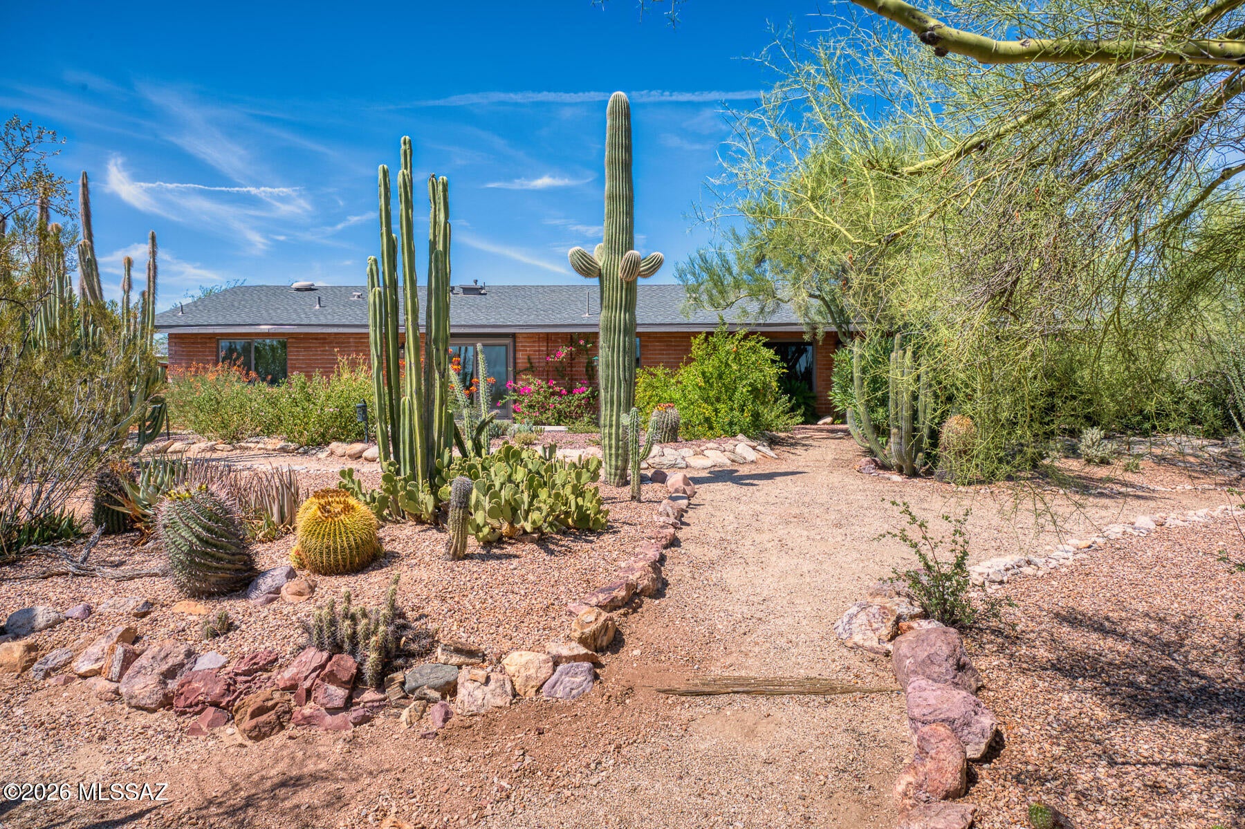 Turnkey Foothills Gem remastered to combine modern conveniences with the charm of the original architecture. Sitting on nearly an acre on a no-outlet street, privacy and nature surround you with charming trails and mountain views. The interior includes exposed brick and travertine floors. The entire property has recently been remodeled (2023) and includes new appliances, hood, mechanical, water heater, roof, driveway, etc. The kitchen combines elegant dual color cabinetry, complimentary quartz and granite countertops with an efficient function any cook would appreciate. No detail was spared in making this home convenient, including smart-home features throughout the house and an EV charger. There are multiple outdoor entertaining areas, a stunning sustainable cactus garden and a detached air-conditioned studio, all with exceptional views and  centrally located.