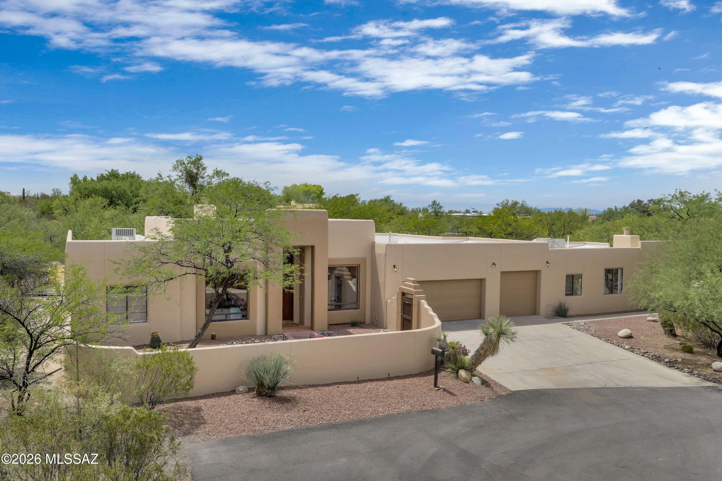Tucked at the end of a quiet cul de sac this fabulous SW hacienda style home is north facing with majestic views of the Catalina Foothills. Inviting courtyard entry, soaring wood beam ceilings, huge picture windows throughout frame the mountains, Saltillo and Talavera tile accents. Main home is thoughtfully designed with 4BR/2.5 BA split floor plan w/spacious living and family rooms provide comfortable gathering spaces complete with fp. Guest quarters has private entry 2 BR/1 BA, kitchen &Fp. 
Delightful backyard that is designed for relaxing and enjoying Tucson's year-round sunshine. The sparkling pool & spa invite you to unwind, while the covered pergola creates the perfect shaded space for outdoor dining or lounging. A detached studio/gym adds even more flexibility for fitness or offic A rare Tanque Verde Valley retreat offering authentic character, expansive space, and endless possibilities. The acre-plus lot provides privacy without sacrificing convenience. Mature desert vegetation, open skies, and mountain views create a peaceful setting, while nearby shopping, dining, golf, and recreation keep everyday life convenient. Access to Sabino Canyon, hiking trails, and the Catalina Foothills lifestyle further enhances the appeal.
This is a home that offers both beauty and function--classic architecture, flexible living spaces, guest accommodations, outdoor enjoyment, and the kind of privacy that is increasingly difficult to find. For buyers looking for authentic Tucson character paired with practical versatility, 9060 E. Indian Bend Rd delivers an exceptional opportunity.