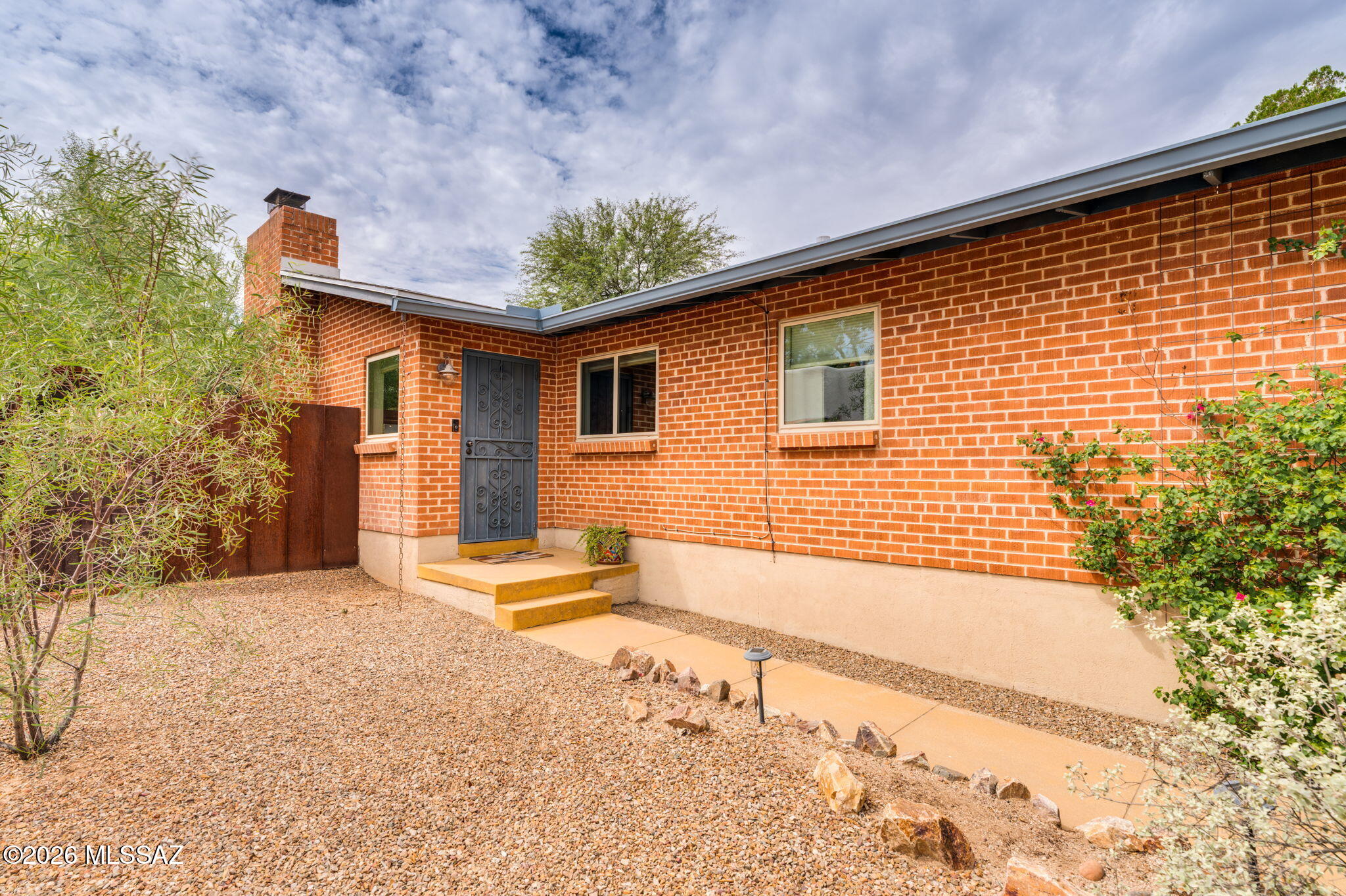 Highly Desired Sam Hughes red-brick charmer! This classic 1953 double-brick bungalow beautifully blends Tucson character with thoughtful modern updates in one of Central Tucson's most sought-after historic neighborhoods. Offering 3 bedrooms, 2 bathrooms and approximately 1,368 sq ft, this inviting single-level home features scored and colored concrete floors, dual-pane windows and a warm living space centered around a wood-burning fireplace with a new mantle.
The renovated kitchen offers stainless steel appliances, gas cooking and generous storage, while the newly remodeled primary bathroom adds a fresh, modern touch. Recent improvements continue with updated lighting throughout, new blinds, a new front door, new R/O system, upgraded gas lines, 2024 water heater, and newer washer and dryer with warranty. Step outside and experience what makes this home special. A large metal roof covered patio extends the living space outdoors, complemented by established desert landscaping, turf, garden areas, custom metal gates and fencing, and a separate bonus/office space not included in the home's reported square footage. Wait till you hear the amazing sound of a desert rain on that patio! New gutters, splash guards and a water-harvesting system add thoughtful desert-living functionality, while a dedicated gas line for the grill makes the backyard ready for entertaining.
And then there's the Sam Hughes lifestyle--enjoy incredible Central Tucson dining, neighborhood favorite Barrio Bread, nearby University of Arizona, convenient access to the Sun Link Streetcar and an extensive network of bike-friendly routes. Historic character, modern improvements and an unmistakably Tucson setting come together in a home that's about much more than where you live--it's how you live. NO HOA,  Bear Down!
