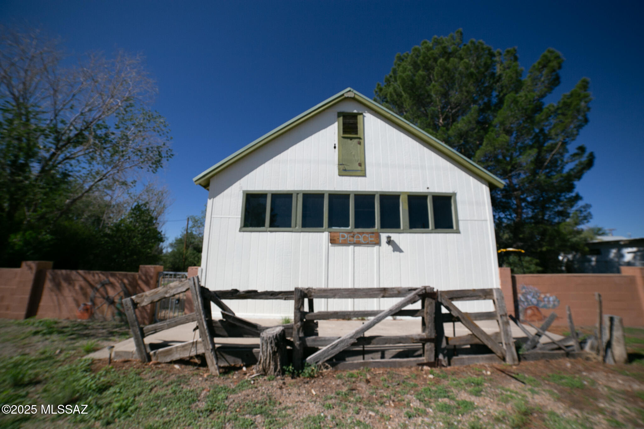This is a historically registered home built in 1918 in the unincorporated town of Cochise. There are magnificent stucco covered ceilings and walls in the large living room area as you enter the foyer., gorgeous original hard wood floors,  arched door ways with hard wood hewn doors with metal hand made hinges. and original shiplap ceilings and walls in other areas.  In the front half of the home there is a space that can be used commercially and once was a general store and the first Cochise Post Office.  Currently used as a large living area for children.   House has upgrade of metal roof and some dual paned windows.  There is a functional well and septic system. Cute guest house with potential next to the carport behind the main house.  Listing also contains an extra adjoining parcel. There is a 396 sq ft building toward the west end of the property that was built in 1920.  It is constructed with a rigid frame and exterior wood walls with a concrete foundation.  The floor is structural slab and the roof is wood joists.  There is electricity and a wall/floor furnace available.  Possibly completed as an studio or apartment.