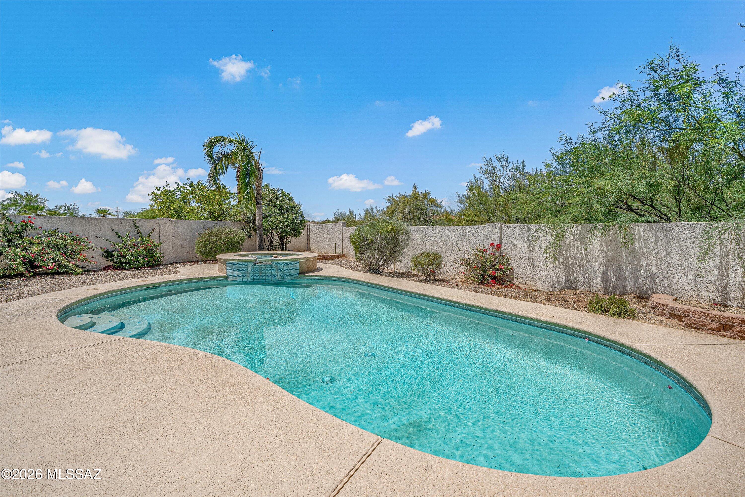 Welcome home to this beautifully maintained Sonoran Desert retreat, perfectly situated on a quiet cul-de-sac in the heart of the highly desirable Rancho Vistoso community! Meticulously updated, this spacious 3BD/2.5BA (2,838 sqft) residence offers a wonderful blend of comfort, functionality, and everyday luxury. Inside, you're greeted by an open, well-designed floor plan featuring soaring vaulted ceilings, plantation shutters, and fresh flooring in the bedrooms. The heart of the home is the expansive kitchen and bar area, which has been upgraded with newly installed granite countertops and a premium built-in Sub-Zero refrigerator, creating a space that is both stylish and practical for grand entertainment. The fireplace in the Great Room and a dedicated wet bar add to th home's sophisticated atmosphere. The split-bedroom plan ensures maximum privacy, featuring a large private primary suite and a versatile den that is perfect for a home office or hobby room. Thoughtful "behind-the-scenes" upgrades abound, including a reverse osmosis system, and upgraded HVAC systems for ultimate peace of mind. Step outside to your own personal resort! The large, extended covered back patio with pavers is perfect for dining alfresco while overlooking the sparkling pool and spa.  The private backyard also features mature citrus trees and borders open space, ensuring no direct rear neighbors and a serene connection to the desert landscape. Complete with a 3-car garage with storage cabinets and a convenient Northwest location near schools and dining, this home is ready for you to move in and start enjoying the Oro Valley lifestyle!