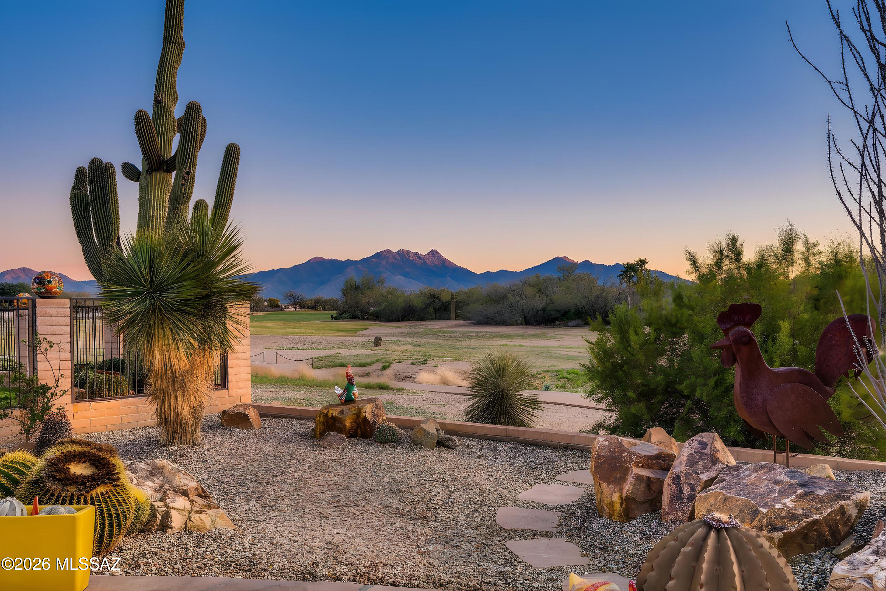 This beautifully situated Laredo model in Quail Creek is perfectly positioned along the golf course, capturing breathtaking mountain views. Designed for extraordinary outdoor living from sunrise to sunset, the home features a refreshing Pebble Sheen pool and extended flagstone patios with outdoor fireplaces, ideal for entertaining or relaxing amid the stunning desert landscape. Exceptional curb appeal welcomes you to this 1,874 sq. ft., 2 BR, 2 BA + Den home, where front desert landscaping is anchored by two majestic saguaro cacti surrounded by native plantings, creating a striking Sonoran Desert setting. A welcoming front entry foyer opens to a spacious great room, where a large window and slider frame sweeping golf course and mountain views, creating a warm, inviting living space. Finishes include fresh interior paint, plantation shutters throughout, tile in the common areas, and carpet in the bedrooms.The remodeled kitchen features granite counters, custom tile backsplash, stainless appliances, a professional 5-burner gas range, custom hood, wall oven, built-in microwave, center island, breakfast bar, and pantry closet. The dining room just off the kitchen provides an ideal setting for gatherings with family and friends. The owner's suite is thoughtfully designed with French doors opening to the covered patio with direct pool access, plus a dual-vanity en suite bath, all-tile shower, and large walk-in closet. A split bedroom floor plan offers privacy for guests with a comfortable guest bedroom and bath, while the versatile den with French doors and a wall bed provides flexible space for an office, hobby room, or additional sleeping accommodations. Plus: New HVAC March 2026.

Designed for true Arizona indoor-outdoor living, the backyard showcases an end-to-end covered patio with a gas fireplace and separate wood-burning kiva fireplace, creating multiple spaces to relax and entertain. All overlook the Coyote Golf Course with panoramic views of Mount Wrightson and Mount Hopkins, along with unforgettable sunrise and sunset vistas. The home also includes a large laundry room, and a 2-car garage plus a separate golf cart garage, providing excellent storage and convenience for enjoying the community's golf and resort amenities. A rare opportunity to enjoy golf course living, mountain scenery, and resort-style outdoor amenities in one of Southern Arizona's premier active-adult communities.