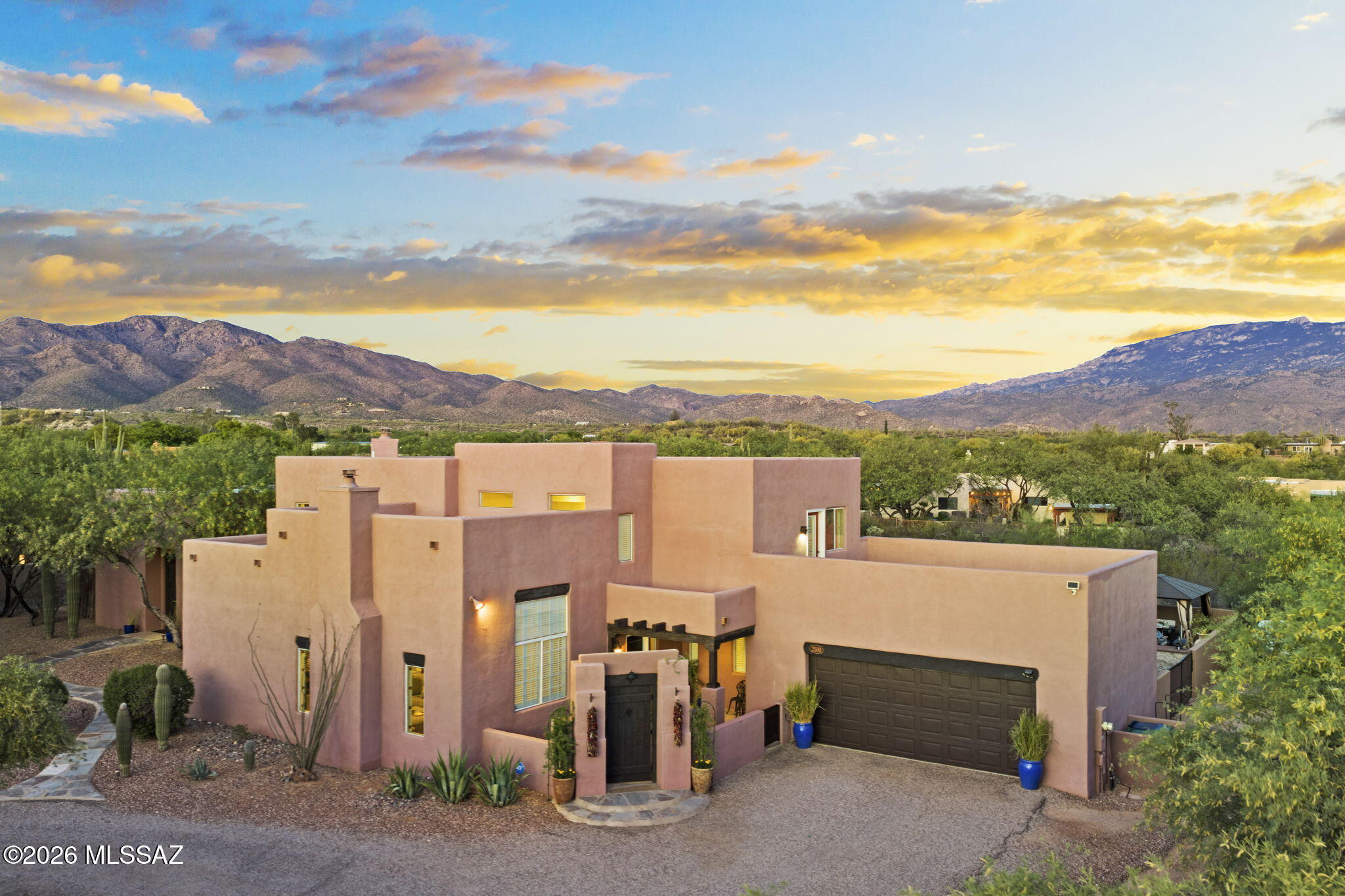 This dramatic Santa Fe-style residence, located in the highly sought-after Tanque Verde Valley, has been extensively upgraded and thoughtfully enhanced. Set on 0.92 acres with mountain and desert views, the property includes a 3,218 sq ft main residence with 4 bedrooms and 3 baths, plus an 860 sq ft detached guest house/studio with private entrance and bath, suitable for guests, multi-generational living, a home office, gym, or studio. The brand-new backyard, as of 2022, now features a pool, gazebo, built-in BBQ area, turf, and professionally designed landscaping. A full block wall and gated entry provide privacy and security, creating a private outdoor setting. The lot extends beyond the walled area, offering additional future potential. Inside, the home was repainted in 2024 and includes updated finishes throughout. The kitchen has been improved with painted cabinetry, upgraded hardware, an expanded pantry, wine refrigerator, and new GE dishwasher and microwave (2025). Bathrooms have also been updated. See attached list of upgrades for full details.
Blending Santa Fe style with modern updates, the home features high ceilings, exposed beams, multiple fireplaces, formal dining, and large living areas designed for both daily use and entertaining. With RV/toy parking and multiple indoor and outdoor gathering spaces, this move-in-ready estate offers privacy, flexibility, and desert living in a highly desirable location.