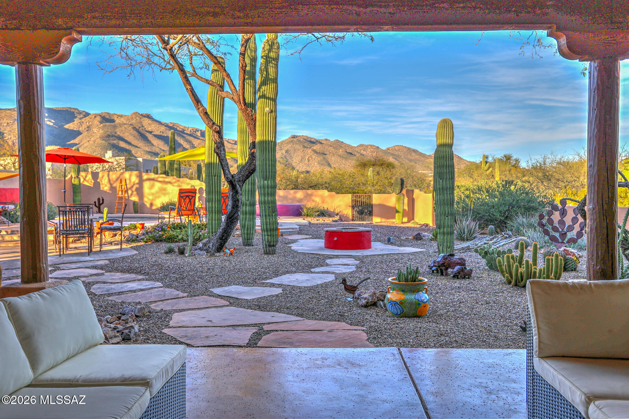Nestled within a small private gated community, this meticulously maintained Santa Fe-style residence captures breathtaking panoramic views at the corner of  the Catalina & Rincon Mountains and Aqua Caliente Peak with a highly desired north-south exposure. A charming gated front courtyard with a tranquil fountain welcomes you into a home rich in authentic southwestern character designed for modern living, featuring wood ceilings with exposed vigas, a custom fireplace, and warm architectural details thru-out. Designed for comfort & flexibility, the thoughtfully planned layout includes two spacious primary suites with private patios and backyard access, ideal for multi-generational  living or extended guests. The secondary primary suite has a private office attached. The 3rd bdrm also has it own ensuite bath, private patio and amazing mountain views. The 4th bdrm is enhanced with a built-in Murphy bed, offering versatility without sacrificing space, with a patio looking out on the secluded courtyard. A convenient full pool bath bridges indoor & outdoor living. The kitchen is appointed with granite counters,custom tile backsplash, center island, 42-inch cabinetry, breakfast nook. Dining room provides an elegant setting for gatherings. Step outside to an extraordinary backyard featuring an extra-length covered patio, outdoor kitchen, outdoor firepit, pebble-tek pool and relaxing spa, professionally landscaped. This exceptional home offers refined desert living at its finest.