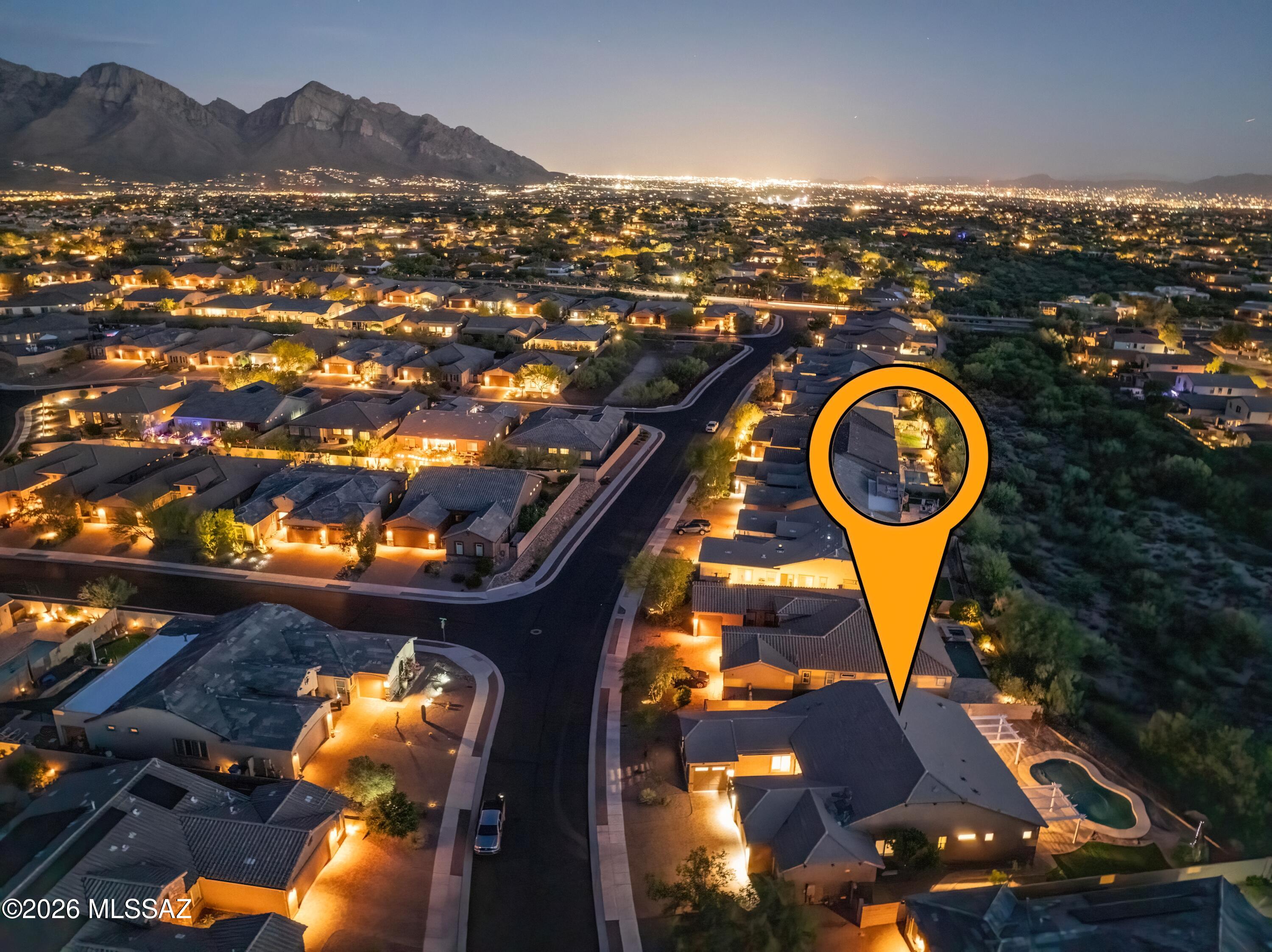 Amazing Oro Valley home with mountain views and unforgettable sunsets, this exceptional residence blends luxury, versatility and Fabulous Arizona living. From the moment you arrive through the custom iron-gated courtyard entrance, every detail of this home reflects elevated design and thoughtful craftsmanship. At the heart of the home is a stunning chef's kitchen designed to impress, featuring top-of-the-line Monogram appliances including a professional-grade range, oven, wine and beverage refrigerator, expansive walk-in pantry, and striking two-tone cabinetry with soft-close finishes. The oversized island anchors the space beautifully, while the open-concept great room is enhanced by a sleek modern fireplace and dramatic 12-foot sliding glass doors that seamlessly blend indoor and outdoor living. Venture outside to a true backyard retreat where resort-style living awaits. A sparkling pool, covered patio with plenty of lounge spaces, elegant paver hardscaping, and lush landscaping create the ultimate setting for entertaining or relaxing beneath Arizona's breathtaking sunsets. The expansive green space bordering the property enhances the sense of privacy while framing picturesque views of the Tortolita Mountains and Catalina vistas beyond. One of the home's most desirable features is the highly sought-after NextGen suite offering the flexibility of private entrance or interior access for a seamless extension of the home. Perfect for multigenerational living, guests, or a private retreat, this beautifully appointed space includes a spacious bedroom with walk-in closet, dedicated laundry area, full kitchenette with refrigerator, sink, dishwasher, and oven, along with direct access to a private patio showcasing Catalina Mountain views. And we can't forget the amazing 4-car garage for all your toys and added space. This remarkable Oro Valley home offers the perfect balance of elegance, comfort, privacy, and space, all with effortless desert living.