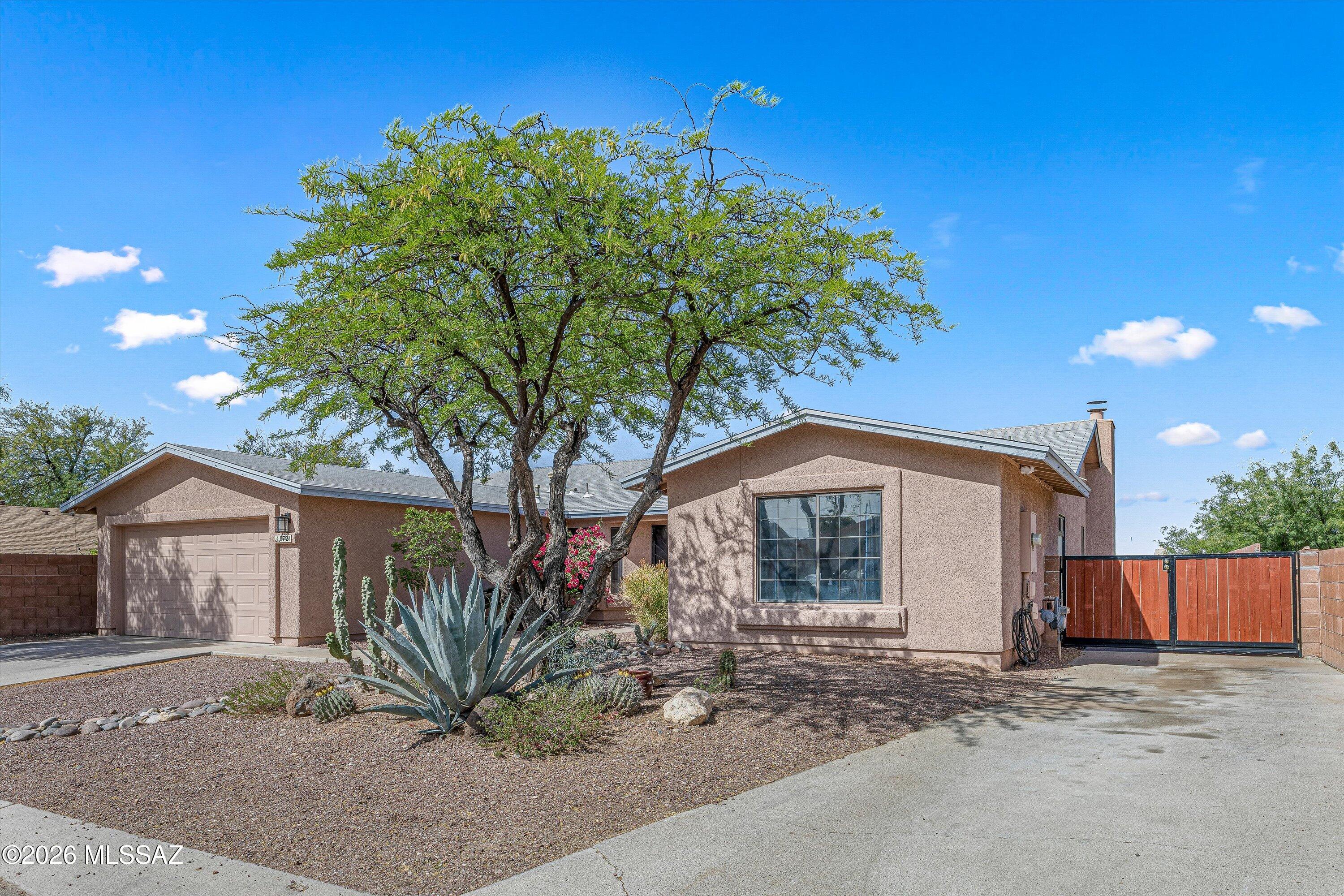 Located in desired NW Tucson, this spacious single-story home offers 4 bedrooms, 2 bathrooms, plus a den and a desirable split floor plan providing both comfort and privacy. The home welcomes you with attractive desert curb appeal and low-maintenance landscaping. Vaulted ceilings create an open and airy feel throughout the main living areas, while the kitchen features granite countertops and a functional layout that flows seamlessly into the family room. The inviting living space includes a cozy fireplace, making it ideal for everyday living and entertaining. The oversized backyard offers a private setting with plenty of space to relax or entertain, as well as room for future possibilities such as adding a pool or creating your ideal outdoor retreat. Enjoy outdoor living with a built-in BBQ, perfect for gatherings, weekend cookouts, or quiet evenings at home. The property also features an RV gate, side gate access, and additional concrete parking, providing flexibility for extra vehicles, recreational equipment, or storage. Situated in a community that offers a pool and park, this home combines a flexible layout, generous outdoor space, and a highly desirable Northwest Tucson location. Sellers are including a one-year home warranty, providing added peace of mind.