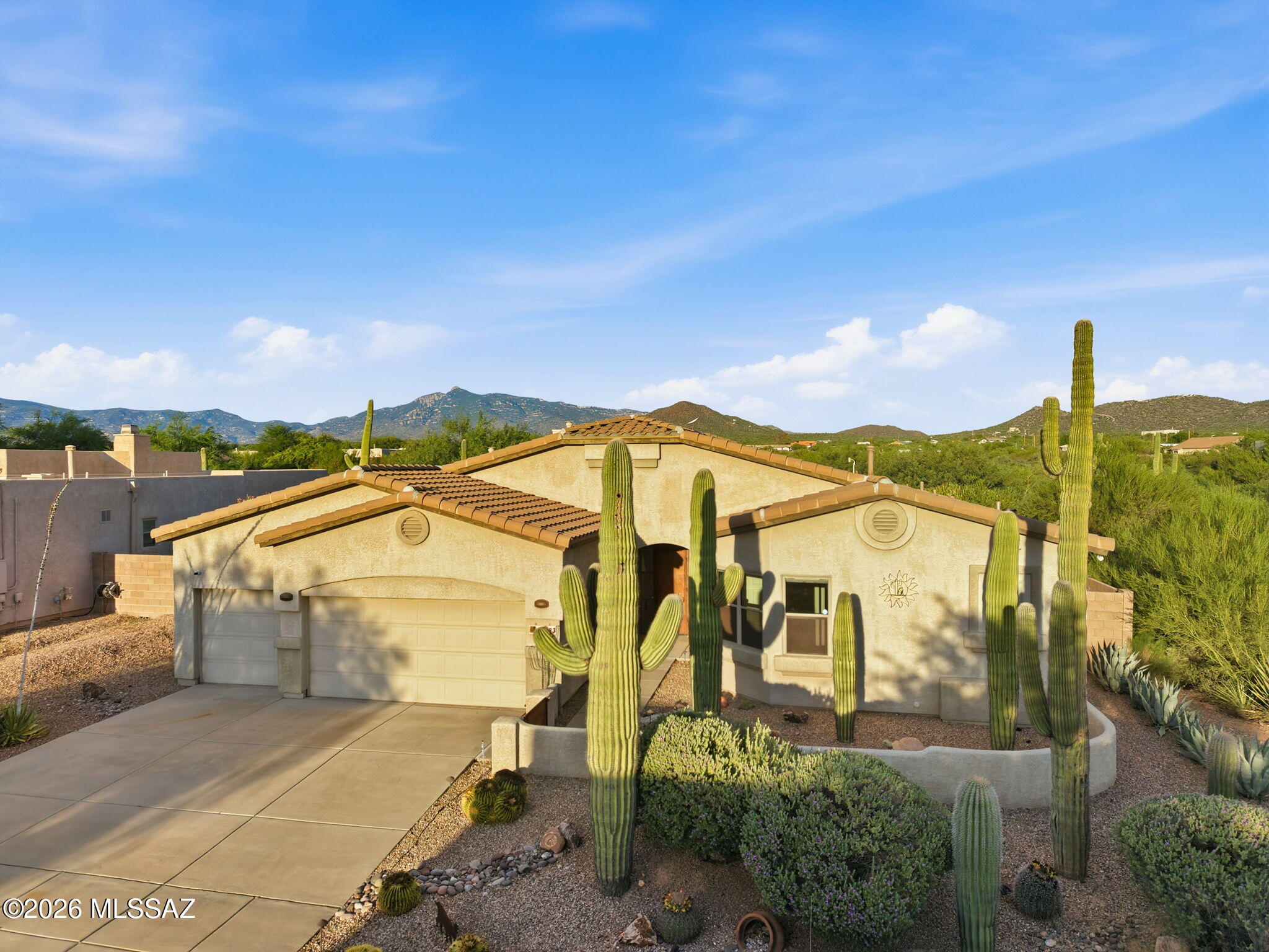 This stunning open-concept custom home features a saguaro-studded courtyard and thoughtful mature Southwest landscaping. Inside, you will find high ceilings, a split floorplan for maximum privacy, dual gas fireplaces in the primary suite and living room, and a massive 3-car garage with storage. The gourmet kitchen features double ovens, S/S appliances, and granite countertops. A bonus den/office provides the perfect workspace, while the windows feature auto-rolling banded blinds. Relax on the extended screened patio with motorized rolling screen shades, or step out to your private paradise: a sparkling PebbleTec pool and spa, a secure turtle/dog run, and a custom outdoor ramada featuring a premium built-in Blackstone griddle. Located in Vail schools, this 3bed/3bath home truly has it all!